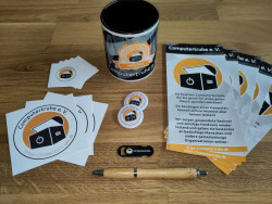 Inhalt des Neumitgliederpakets: Sticker, Flyer, eine Tasse, Buttons, ein Kugelschreiber und Kameraabdeckung
